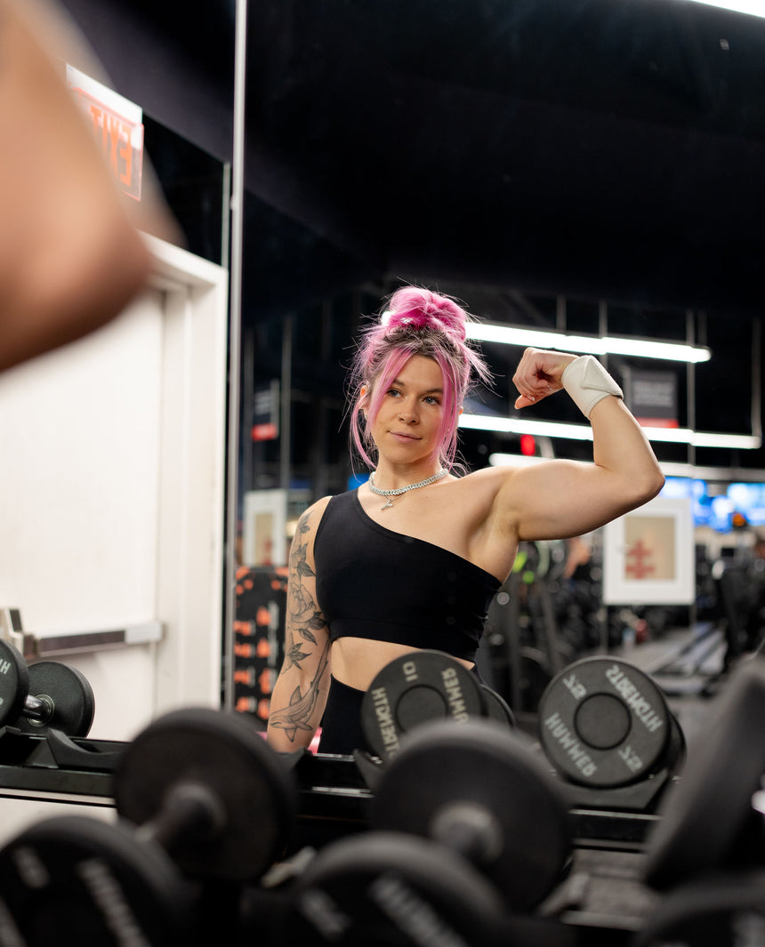 iulia flexing her bicep at the gym