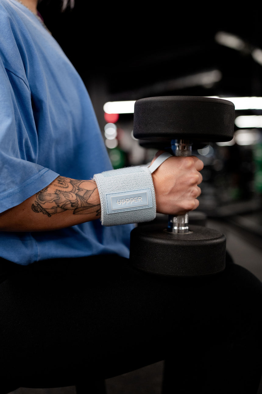 woman wearing uppper wrist wraps and holding dumbbells